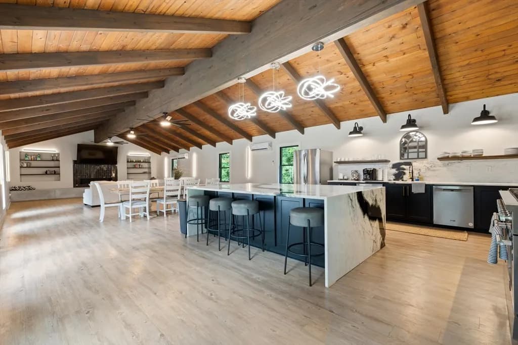 Ivy & Oak luxury kitchen with vaulted wood beam ceilings and marble waterfall island